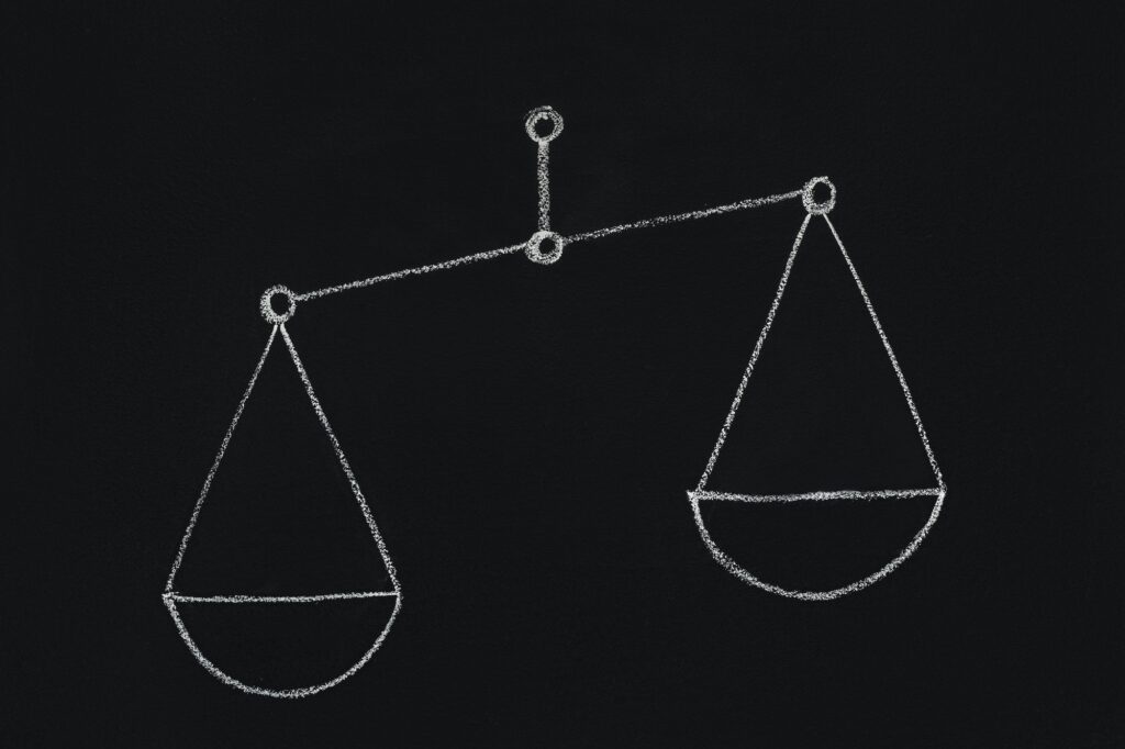 Drawn scales with empty cups on chalkboard